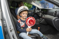 Ein Junge mit Polizeimütze und Kelle