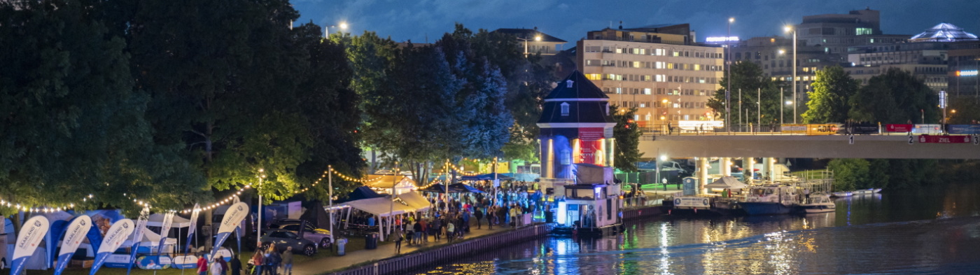 Festlich beleuchtete Boote abends entlang der Saar